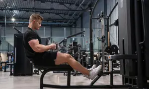 Man tränar ryggpass på gym med kabelmaskin.