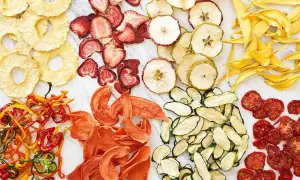 En färgsprakande samling av torkad frukt och grönsaker, som ananasringar, jordgubbar, äppelskivor, mango, paprika, aprikoser, zucchini och tomater. Ett nyttigt snacks!