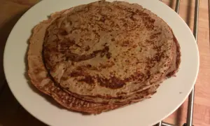 En hög med gyllenbruna proteinpannkakor på en vit tallrik. Perfekt för ett snabbt och näringsrikt proteinpannkakor recept.