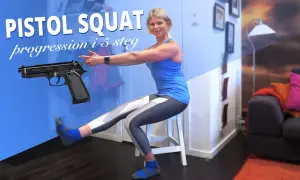 Kvinna utför pistol squat, en övning som bygger starka pistol squat muskler. En pistol är placerad bredvid henne.