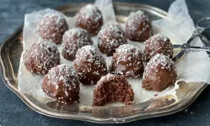 Chokladiga havrebollar med kokos på ett silverfat. Ett perfekt recept för hemmagjorda godsaker.