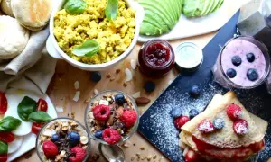 En härlig vegansk frukost med pannkakor, smoothies, granola, tofu scramble och färska bär.