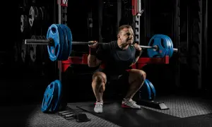 Man gör tunga squats svenska i gym.