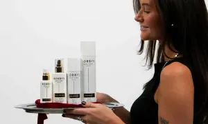 En kvinna presenterar en bricka med Bobby's Hair Care-produkter, inklusive Bobby's Curl Cream, för perfekt lockigt hår.