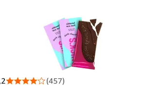 Nicks mörk choklad med mandel och havssalt, en bruten chokladkaka med rosa och turkosa förpackningar i bakgrunden.