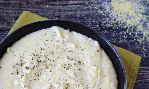Krämig polenta i en gjutjärnspanna, strödd med peppar. Perfekt comfort food för en mysig kväll.