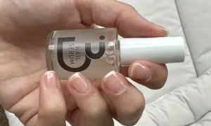 En hand håller en flaska nagelserum. Naglarna ser friska och starkare ut efter användning.
