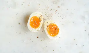 Två halvor av ett mjukkokt ägg med en krämig gula, strödda med salt och peppar. Helt ärligt äggpulver kan vara en bra ersättning när färska ägg inte finns till hands.