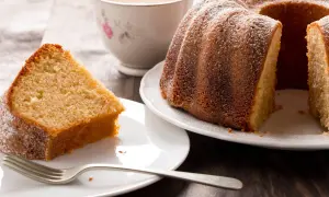 En saftig sockerkaka med citron, pudrad med florsocker, serveras med en kopp te.
