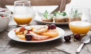 En lyxig frukost med frukt, apelsinjuice och små smörgåsar. En perfekt start på dagen.