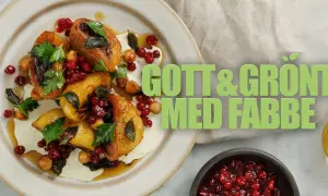 En tallrik med gyllene, grillade grönsaker, toppad med krämig sås, lingon och örter. Perfekt för att grilla vegetariskt!