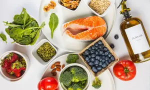 En tallrik med lax, bär, grönsaker och nötter. Ingredienser för en antiinflammatorisk kost.