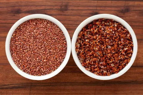 Två skålar med quinoa, en med råa frön och en med kokt. Quinoa är en utmärkt källa till komplexa kolhydrater.