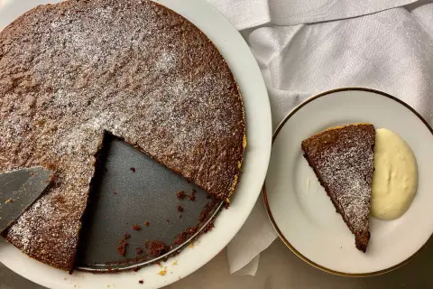 Chokladkaka med pudersocker, en bit serverad med grädde. Perfekt att baka på 10 minuter!