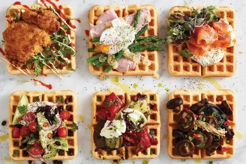 Sex olika matiga våfflor: med friterad kyckling, pocherat ägg och sparris, rökt lax, avokado och bönor, grillade grönsaker och ost, samt svamp.