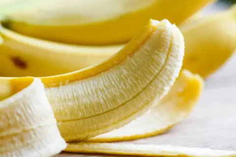 En delvis skalad banan, som visar den vita insidan. En perfekt och nyttig mellanmål.