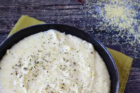 Krämig polenta i en gjutjärnspanna, strödd med peppar. Perfekt comfort food för en mysig kväll.