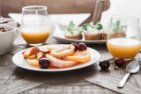 En lyxig frukost med frukt, apelsinjuice och små smörgåsar. En perfekt start på dagen.