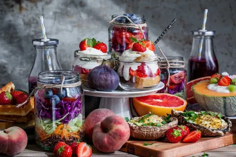 En härlig brunch meny med färgglada burksallader, fyllda champinjoner, frukt och desserter i glas.