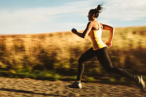 Kvinna springer i hög fart på en grusväg, en del av ett intensivt hiit pass.