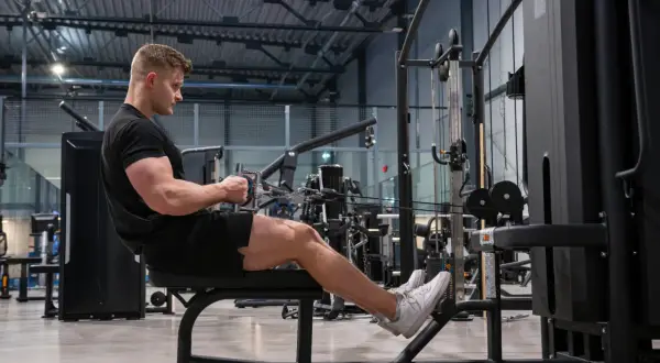 Man tränar ryggpass på gym med kabelmaskin.