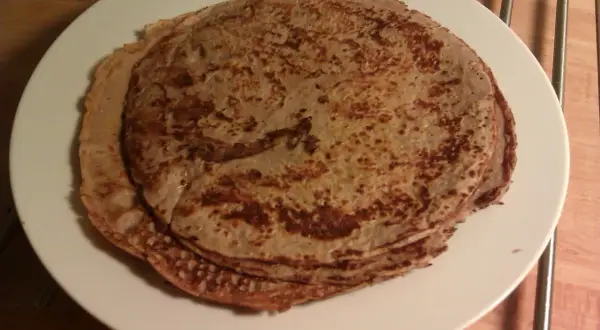 En hög med gyllenbruna proteinpannkakor på en vit tallrik. Perfekt för ett snabbt och näringsrikt proteinpannkakor recept.