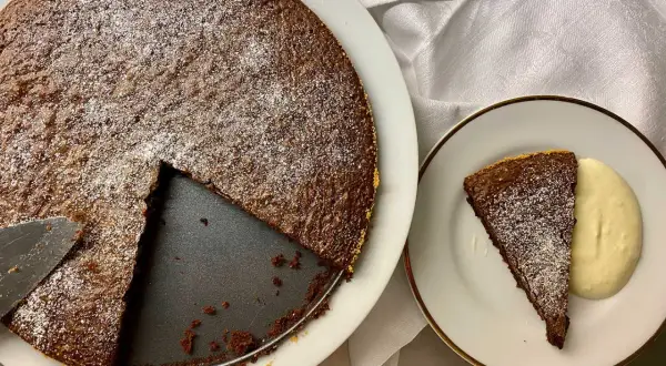 Chokladkaka med pudersocker, en bit serverad med grädde. Perfekt att baka på 10 minuter!