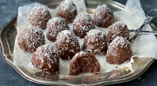 Chokladiga havrebollar med kokos på ett silverfat. Ett perfekt recept för hemmagjorda godsaker.