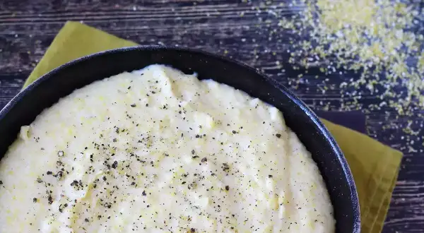 Krämig polenta i en gjutjärnspanna, strödd med peppar. Perfekt comfort food för en mysig kväll.