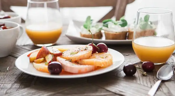 En lyxig frukost med frukt, apelsinjuice och små smörgåsar. En perfekt start på dagen.