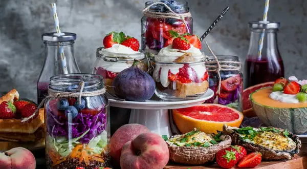 En härlig brunch meny med färgglada burksallader, fyllda champinjoner, frukt och desserter i glas.