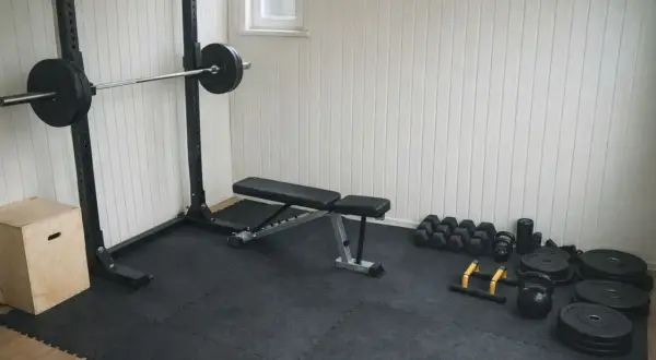 Hemmagym med skivstångsställning, bänk, hantlar, kettlebells och box. Ett komplett gym schema för träning hemma.