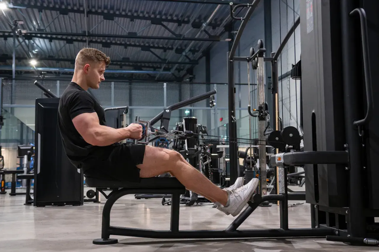 Man tränar ryggpass på gym med kabelmaskin.