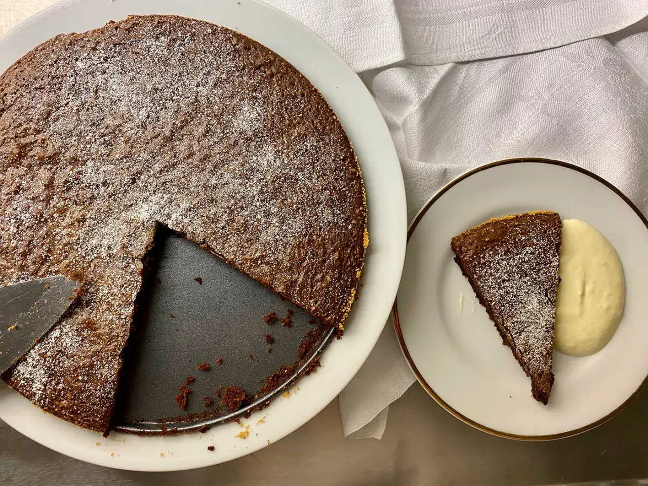 Chokladkaka med pudersocker, en bit serverad med grädde. Perfekt att baka på 10 minuter!