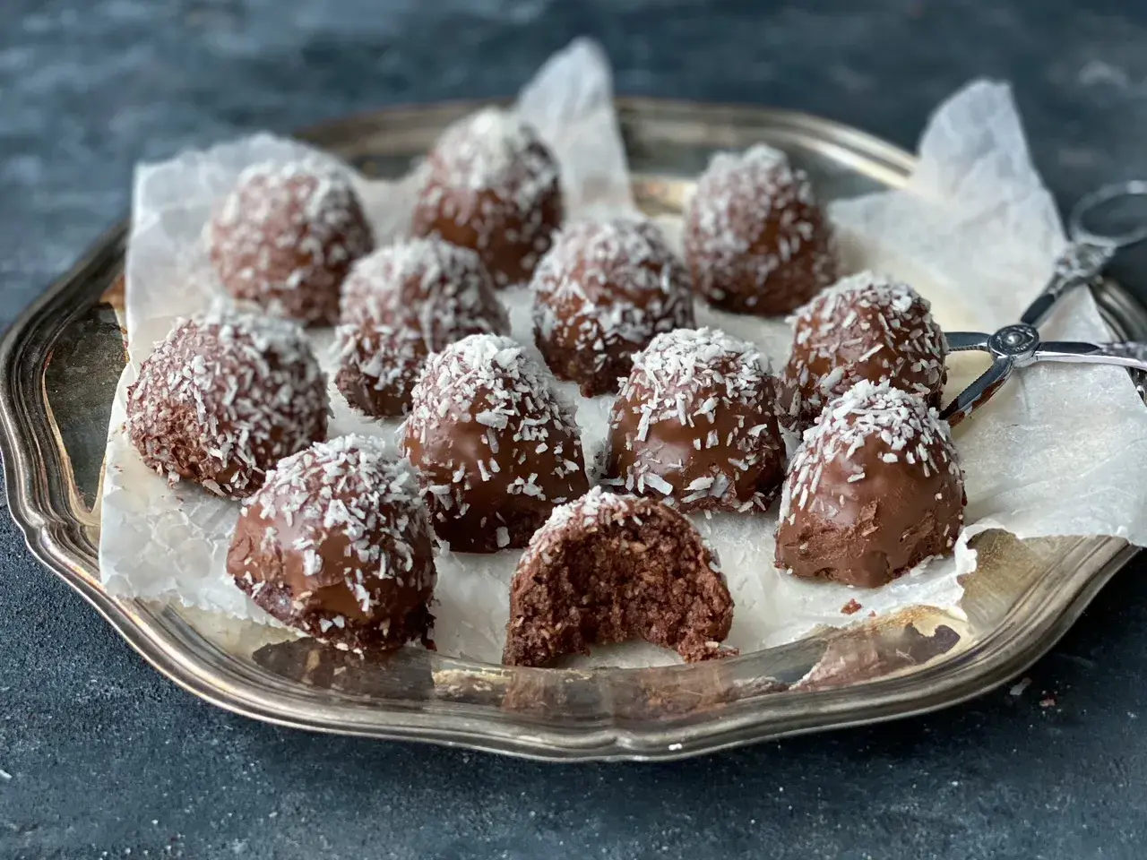 Chokladiga havrebollar med kokos på ett silverfat. Ett perfekt recept för hemmagjorda godsaker.