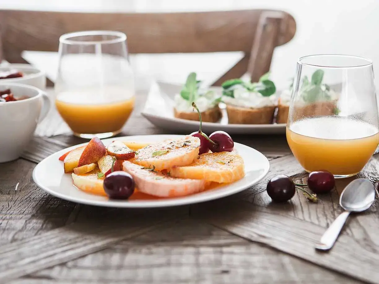 En lyxig frukost med frukt, apelsinjuice och små smörgåsar. En perfekt start på dagen.