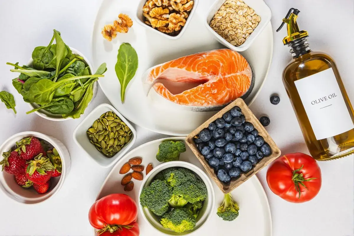 En tallrik med lax, bär, grönsaker och nötter. Ingredienser för en antiinflammatorisk kost.
