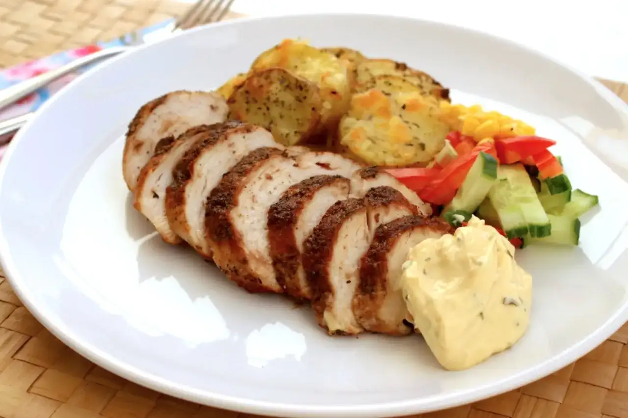 Skivad kycklingfile i ugn med rostade potatisskivor, majs, paprika, gurka och en klick majonnäs.