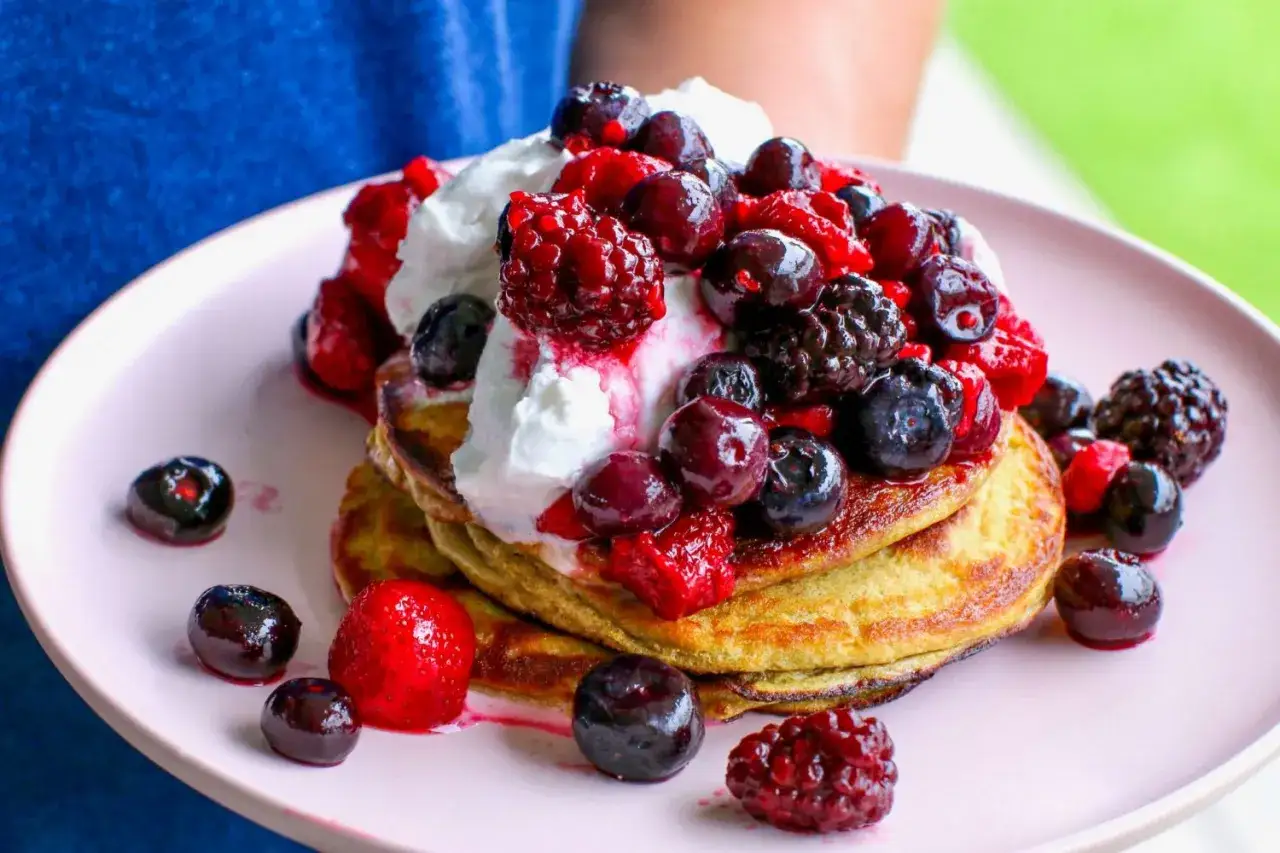 En h&ouml;g med fluffiga proteinpannkakor toppas med vispad gr&auml;dde och en gener&ouml;s m&auml;ngd f&auml;rska b&auml;r. Ett perfekt proteinpannkakor recept f&ouml;r en h&auml;lsosam frukost.