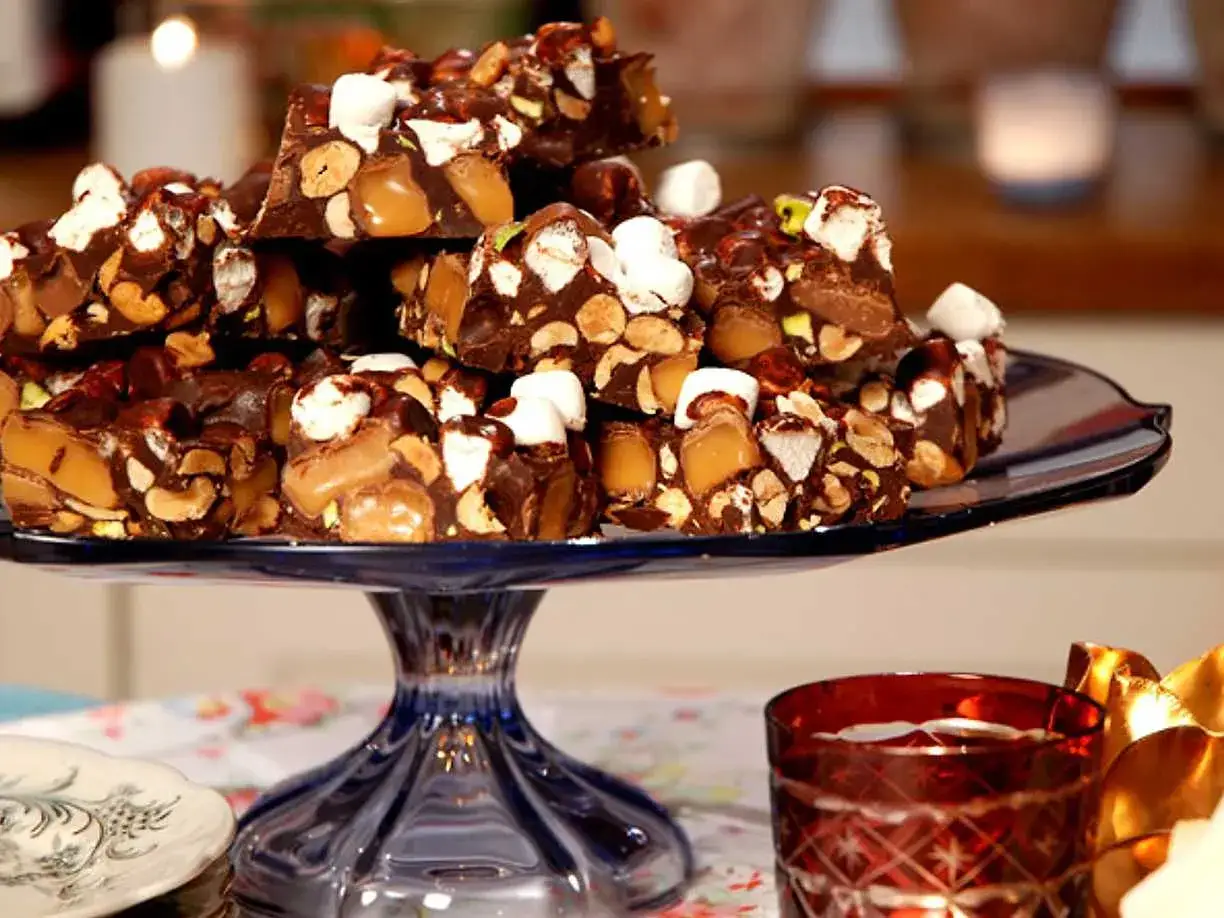 En h&ouml;g med klassisk rocky road p&aring; ett bl&aring;tt fat. Chokladbitarna &auml;r fyllda med n&ouml;tter, karamell och marshmallows.