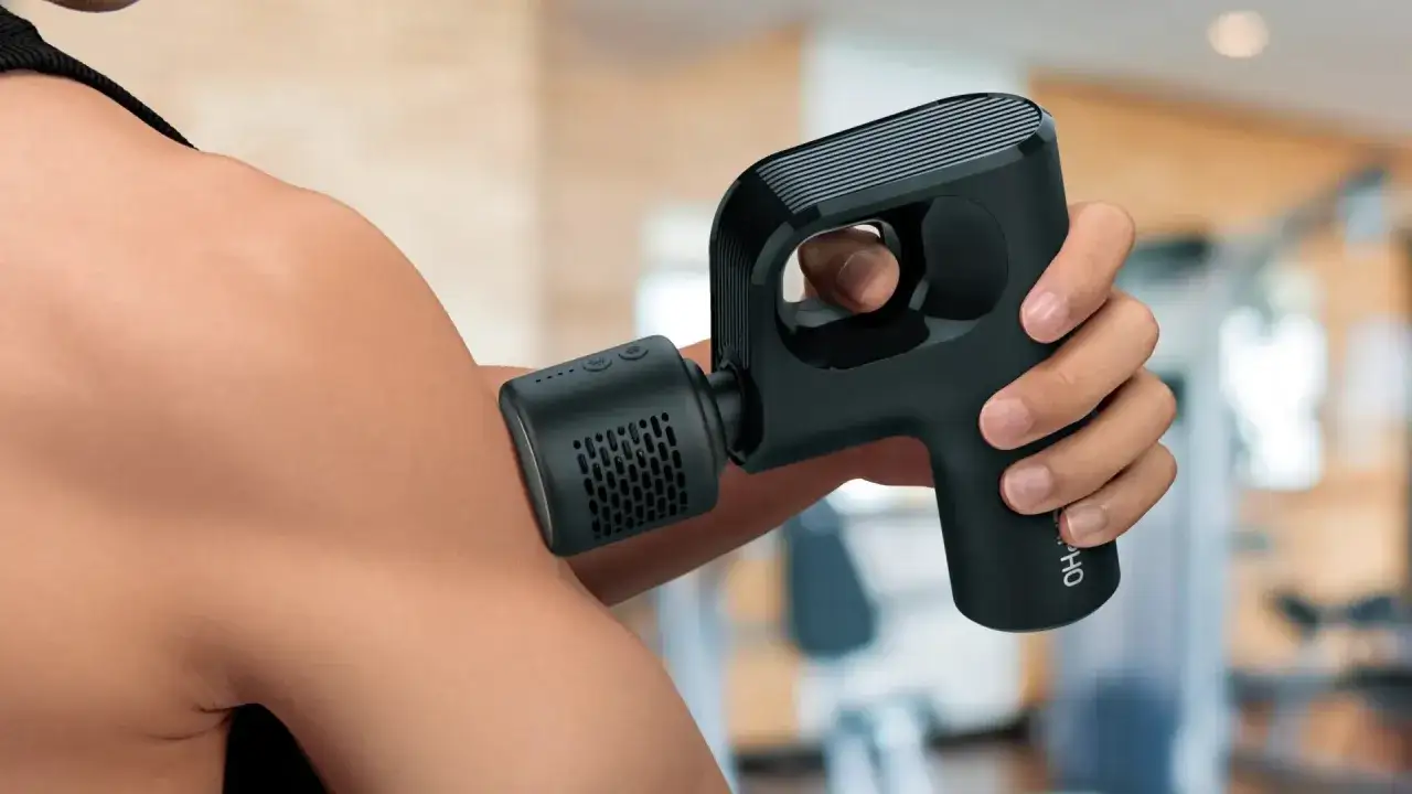 En person anv&auml;nder en Rubicson massagepistol mini f&ouml;r att massera axeln.