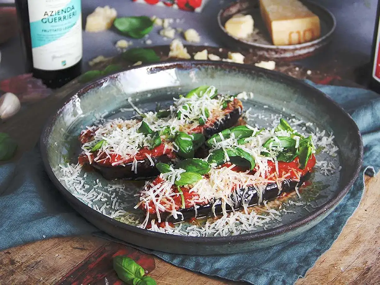 Aubergine recept: halverade auberginer toppade med tomats&aring;s, basilika och riven ost. Enkelt och gott!