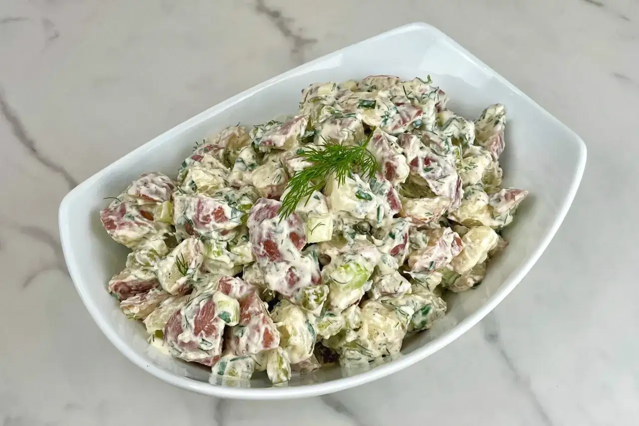 Kr&auml;mig potatissallad med dill och gr&auml;sl&ouml;k, en del av en antiinflammatorisk kost. Potatisen &auml;r varsamt tillagad och blandad med en len dressing.