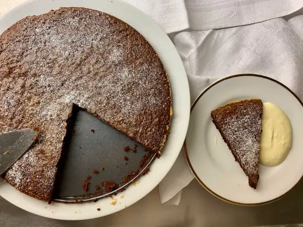 Chokladkaka med pudersocker, en bit serverad med grädde. Perfekt att baka på 10 minuter!