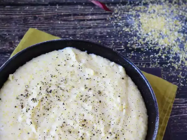 Krämig polenta i en gjutjärnspanna, strödd med peppar. Perfekt comfort food för en mysig kväll.
