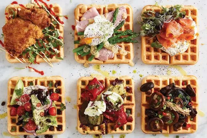 Sex olika matiga våfflor: med friterad kyckling, pocherat ägg och sparris, rökt lax, avokado och bönor, grillade grönsaker och ost, samt svamp.